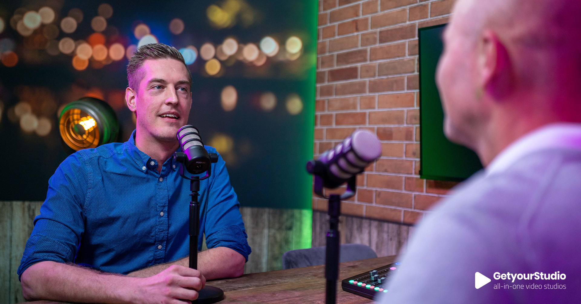 Podcastopname in een corporate in-house studio van GetyourStudio, met professionele microfoons, sfeerverlichting en moderne studioafwerking