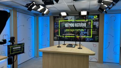 Estudio de video de GetyourStudio con tres micrófonos, iluminación de estudio, pantallas de video y cámaras PTZ de Canon en una configuración profesional